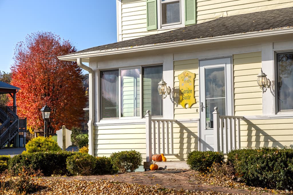 Private entrance to Garden Suite porch at foursquare yellow farmhouse.